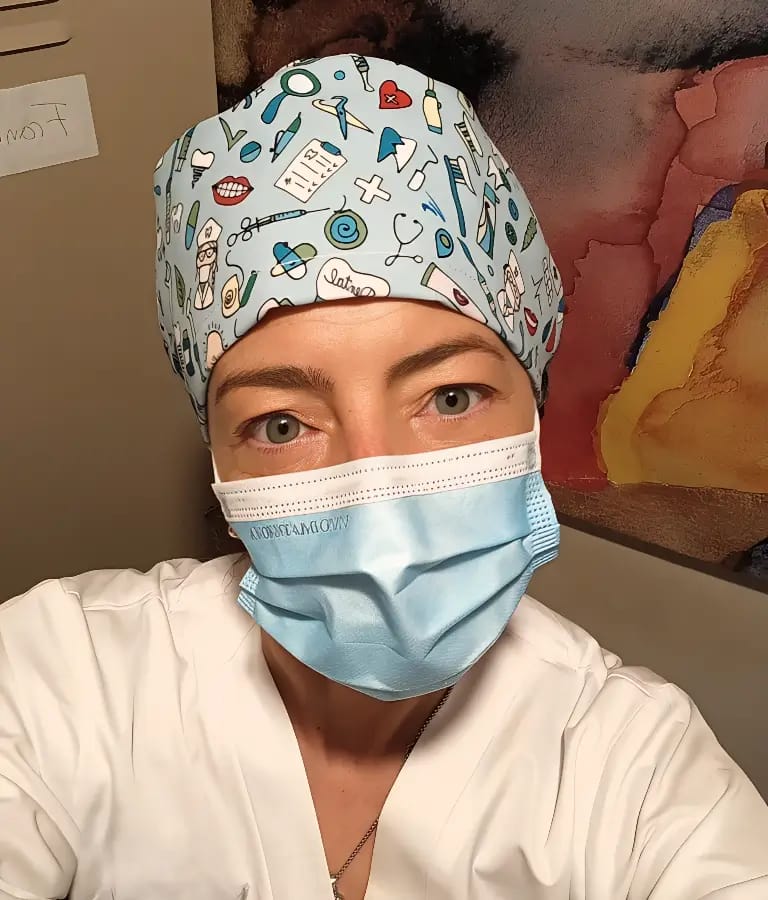 Persona con uniforme sanitario, mascarilla y gorro médico estampado, transmitiendo profesionalidad y cercanía