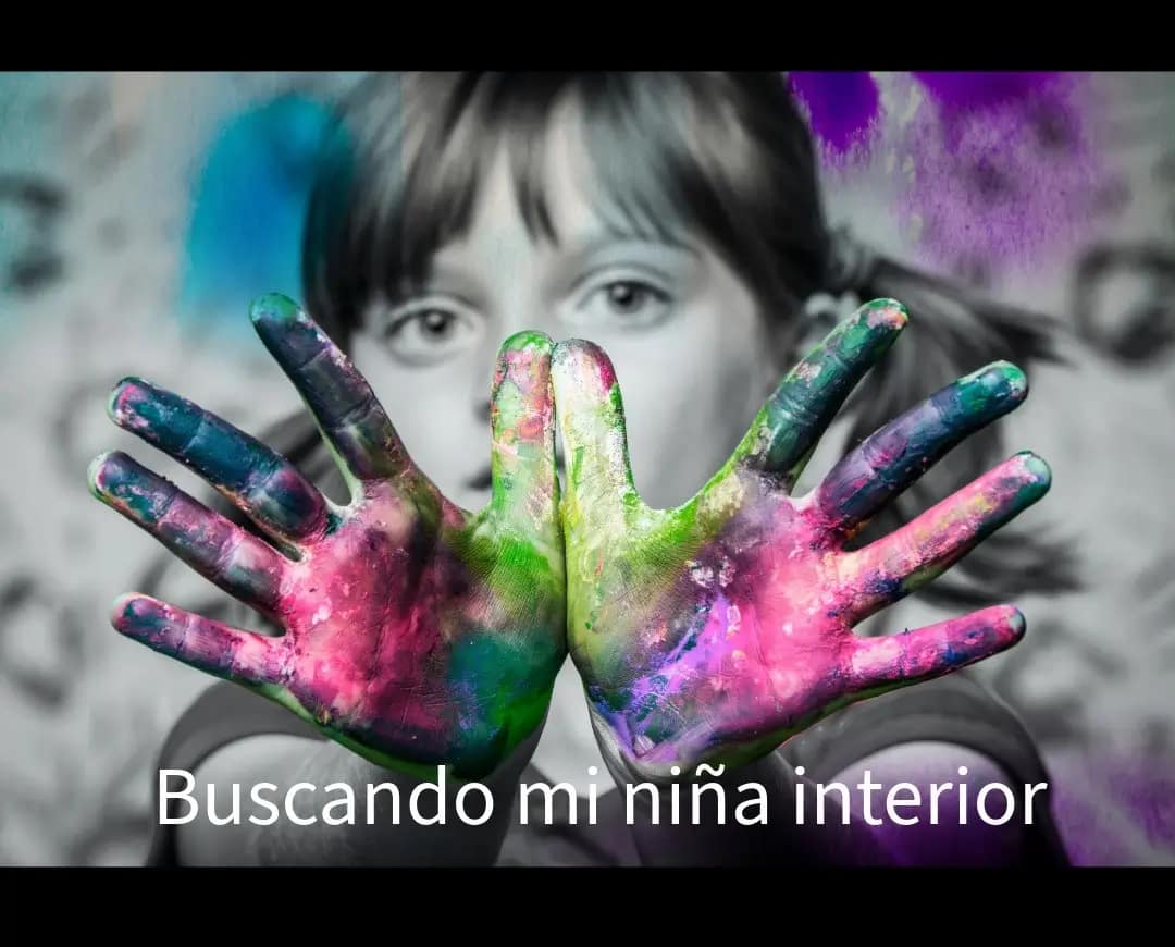 Niña en blanco y negro con las manos pintadas de colores, simbolizando la búsqueda de la niña interior, la conexión emocional y el proceso de sanación.