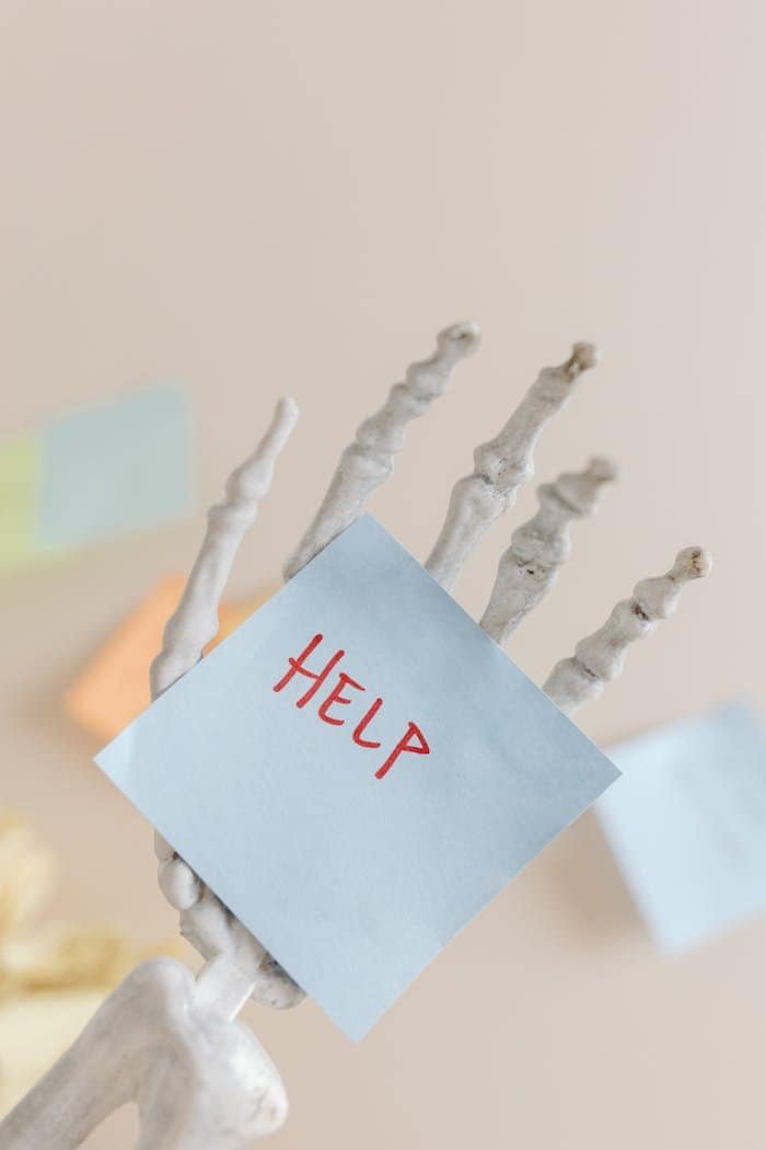 Mano levantando un cartel con la palabra "Help" simbolizando apoyo emocional y ayuda ante la depresión y ansiedad