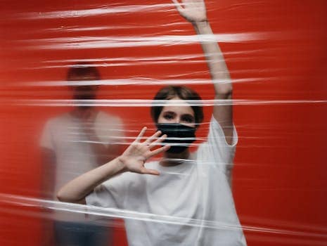 Mujer con expresión triste detrás de un plástico transparente que simboliza el aislamiento emocional en la distimia y la depresión crónica